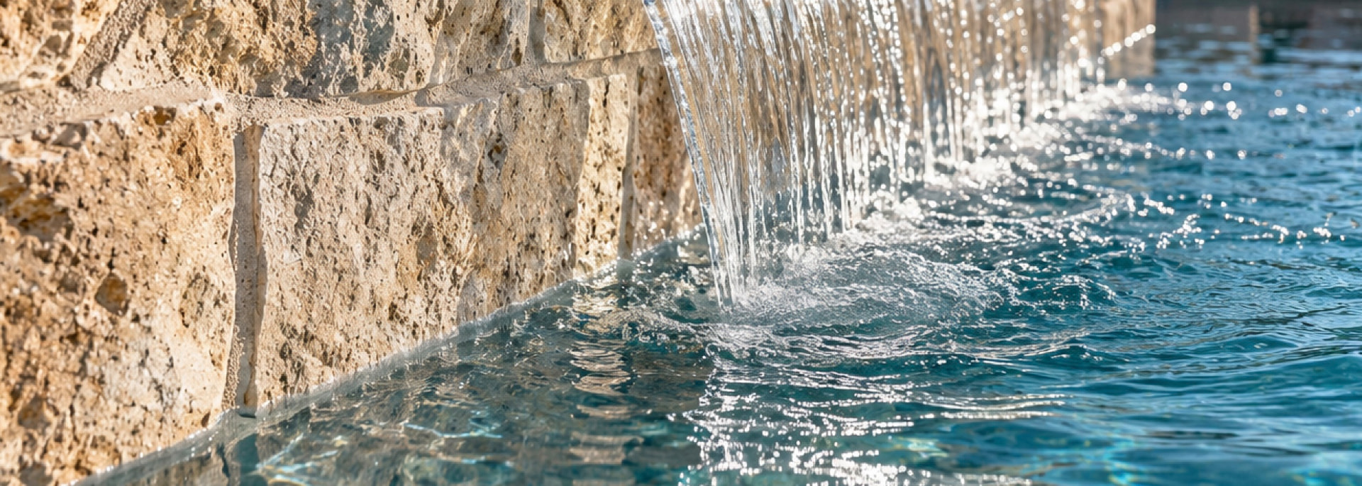 Custom pool with a stone waterfall and integrated water features